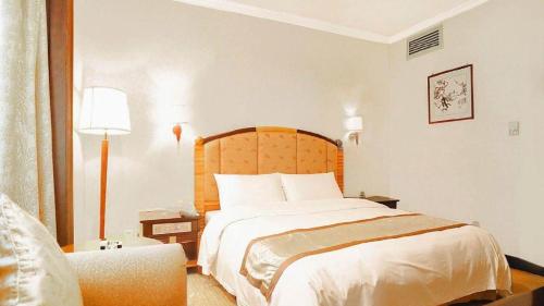 a hotel room with a bed and a chair at Quanzhou Royal Prince Hotel in Quanzhou