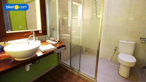 a bathroom with a sink and a toilet and a shower at Griya Jogja Hotel in Yogyakarta