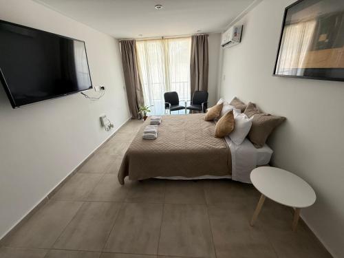a bedroom with a bed and a flat screen tv at Altos de Ezeiza in Ezeiza