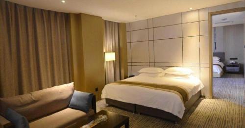 a hotel room with a bed and a couch at Harbin Splendent Hotel in Harbin