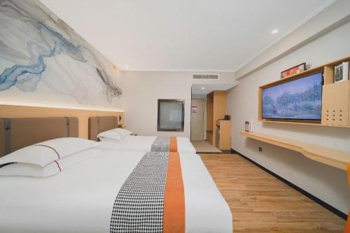 a large bedroom with a large bed and a flat screen tv at JIAN AI XI YUE HOTEL in Yiwu