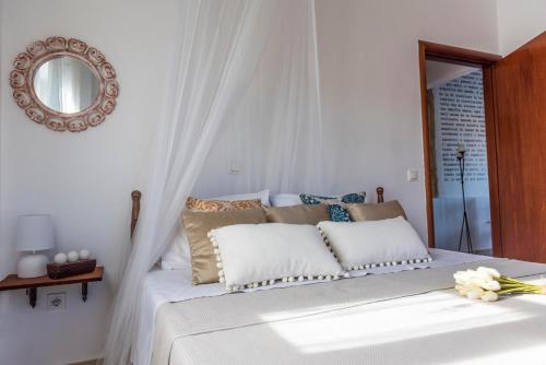 a bedroom with a white bed with pillows and a mirror at Finestra Medieval Home in Rhodes Town