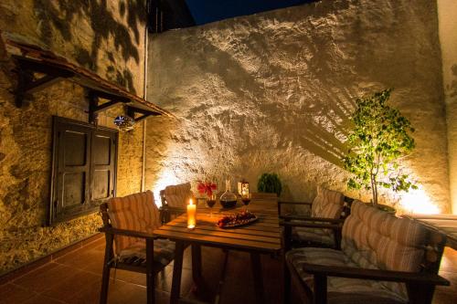 a wooden table with chairs and a candle on it at Finestra Medieval Home in Rhodes Town