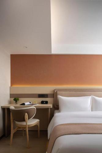 a bedroom with two beds and a chair and a desk at Immersing Hotel Guilin Two Rivers and Four Lakes Dongxi Alley in Guilin
