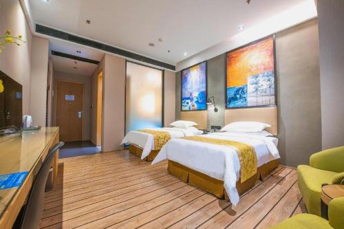 Una habitación de hotel con dos camas y un televisor. en MAIHAOHOTELS, en Sanjiang