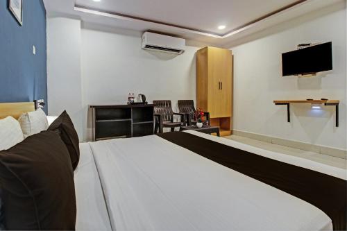 a hotel room with a bed and a tv at Hotel O Qualia Miyapur in Hyderabad