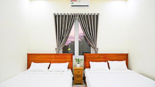 ホーチャムにあるMotel Thuỷ Lộc Hồ Tràmの窓のある部屋にベッドが2つある