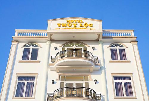 ホーチャムにあるMotel Thuỷ Lộc Hồ Tràmの上に看板がある白い建物