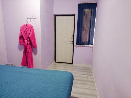 a pink robe hanging on a wall in a room at Asian Guest House in Bishkek