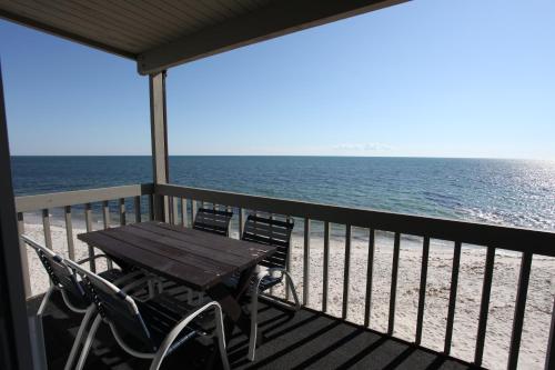 a table and chairs on a balcony overlooking the ocean at Surfcomber On The Ocean in South Yarmouth