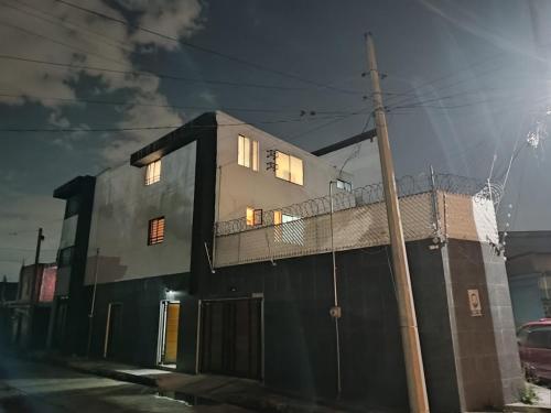 a house with the lights on on a street at Hotel Origins in Cholula
