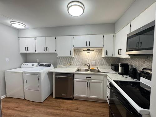 a kitchen with white cabinets and a sink at 2 Bedroom Townhouse in Charlotte