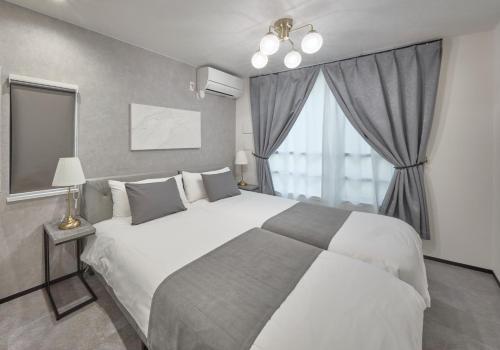 a bedroom with a large bed and a window at ルチル池袋東京 in Tokyo