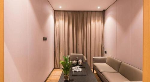 a living room with a couch and a table at Green Tree Inn Express Fuzhou Three Lanes and Seven Alleys Nanmendou Metro Station in Fuzhou