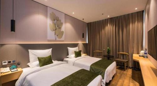 a hotel room with two beds and a desk at Green Tree Inn Express Fuzhou Three Lanes and Seven Alleys Nanmendou Metro Station in Fuzhou