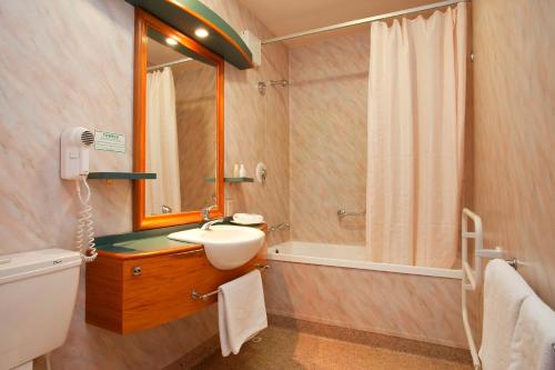 a bathroom with a sink and a mirror at Distinction Heritage Gateway Hotel in Omarama