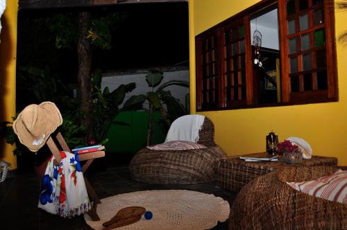 a living room with wicker chairs and a table at Pousada 100 Passos in Tamandaré