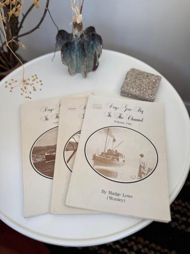a white plate with three books on a table at Blyth Retreat, Bruny Island in Simpsons Bay