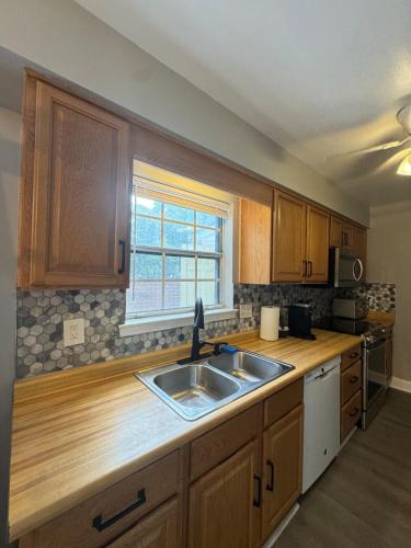 a kitchen with wooden cabinets and a sink and a window at 3 bedroom Town home in Charlotte