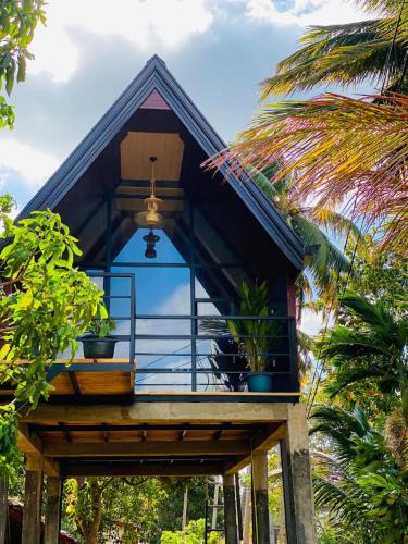 a house with a balcony with plants on it at The Warming Nest Tree House in Sigiriya