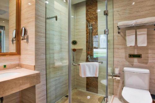 a bathroom with a shower and a toilet and a sink at Vienna Hotel Kunming Beijing Road Chuanxin Gulou Metro Station in Kunming