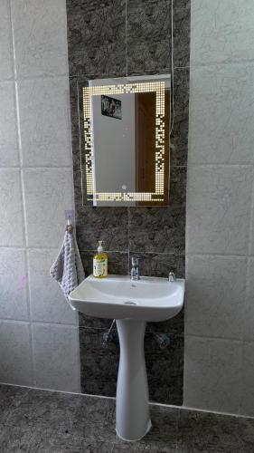 a bathroom with a sink and a mirror at NIRA Luxe stay in Lucknow