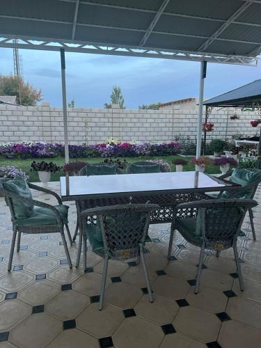 a table and chairs sitting under an umbrella at Guest House "MIDNIGHT" in Talas
