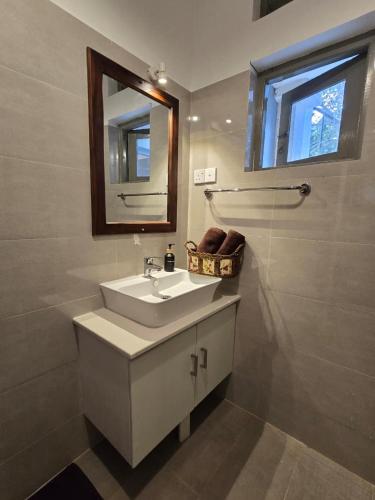 a bathroom with a sink and a mirror at The Cottage Kandy in Kandy