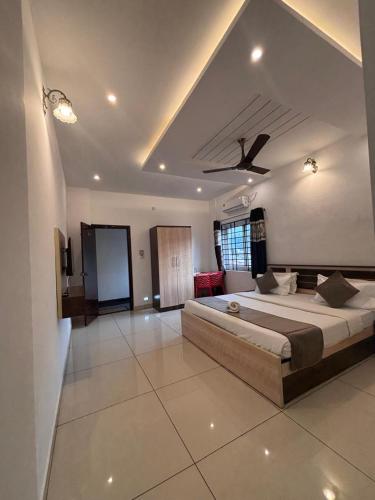 a bedroom with a large bed and a ceiling at Prashanth Residency Madikeri in Madikeri