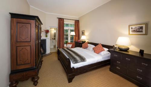 Hill Rise Luxury Villa & Stables by Edwards Collection في نوارا إليا: غرفة نوم مع سرير كبير مع خزانة وخزانة