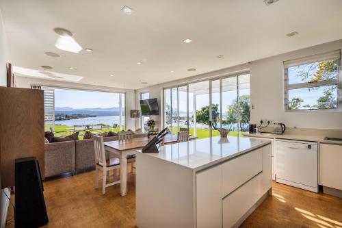 a kitchen and living room with a view of the ocean at No1 Sangaree in Plettenberg Bay