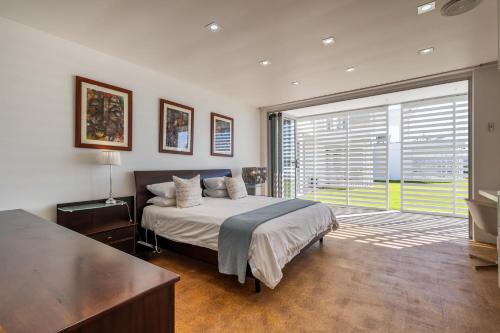 a bedroom with a bed and a large window at No1 Sangaree in Plettenberg Bay