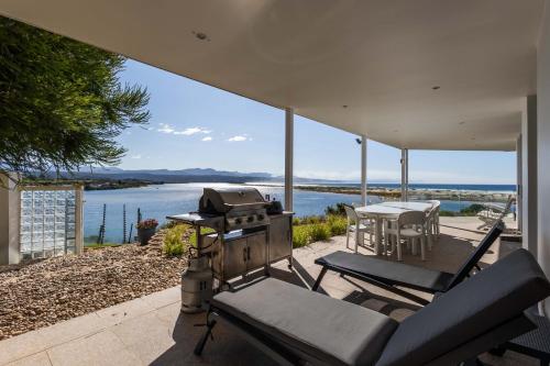 a patio with a grill and a table and chairs at No1 Sangaree in Plettenberg Bay