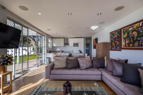 a living room with a couch and a kitchen at No1 Sangaree in Plettenberg Bay