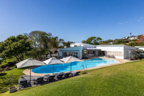a house with a swimming pool and umbrellas at No1 Sangaree in Plettenberg Bay