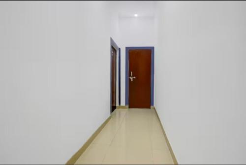 a hallway with a door in a white room at Shubhang guest house in Varanasi