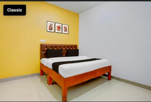 a bed in a room with a yellow wall at Shubhang guest house in Varanasi