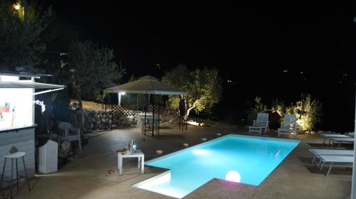 a swimming pool in a backyard at night at B&B Eyexei Domus in Agrigento