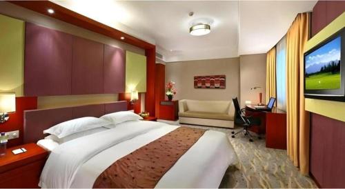 a bedroom with a large bed and a television at Xiamen Jingmin Central Hotel in Xiamen