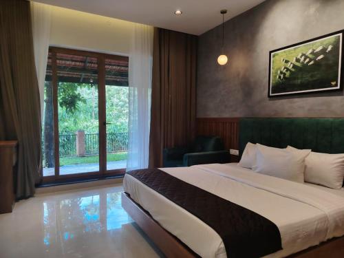 a hotel room with a bed and a window at Athirapilly Ontherocks in Athirappilly