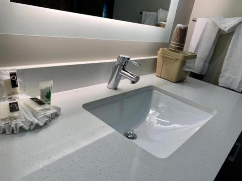 a white sink in a bathroom with a mirror at Pacific Motor Inn in San Jose