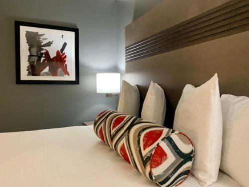 a bedroom with a bed with white pillows at Pacific Motor Inn in San Jose