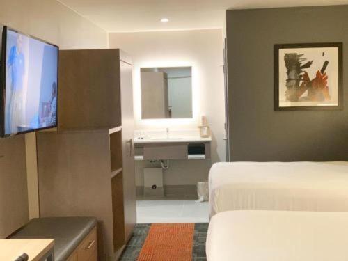 a hotel room with two beds and a television at Pacific Motor Inn in San Jose