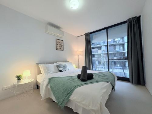 a bedroom with a bed with a cat sitting on it at Cozy 2B apartment in Belconnen GYM POOL in Belconnen
