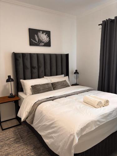 a large bed with a black headboard in a bedroom at InWeFT Coastal Homes Apartment B in Swakopmund