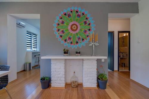 a living room with a fireplace with a clock on the wall at Luxury Apartment with Private Heated Pool in Šibenik
