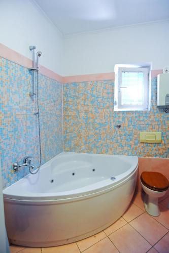 a bathroom with a tub and a toilet at Apartments Domalu in Zadar