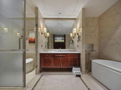 a bathroom with a tub and a sink and a bath tub at Dongwu New Century Grand Hotel Huzhou in Huzhou