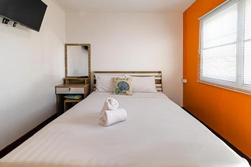 a bedroom with a bed with a towel on it at Karoon Sea View Lodge in Hua Hin