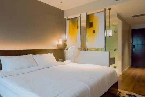 a bedroom with a large white bed and a mirror at The Residences at Novotel Tower in Manila